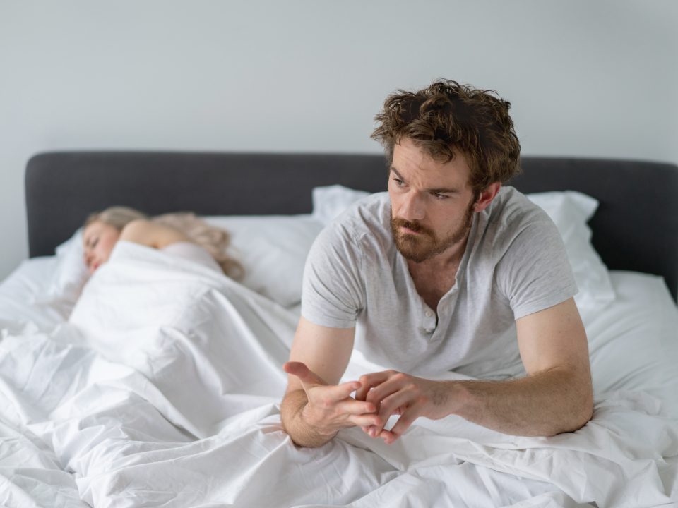 Man in bed looking upset